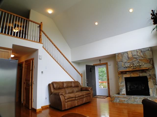 Gorgeous main level living room boasts a cathedral ceiling with BIG windows oak cabinets in the open kitchen fireplace and beautiful hardwood floors, Franklin NC Homes for Sale, John Becker Bald Head