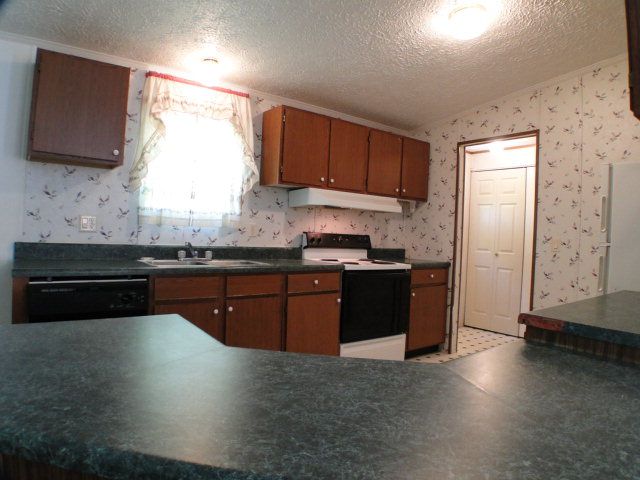 There is a lovely open kitchen with plenty of work space and an attached laundry area, John Becker Bald Head Realty Franklin NC