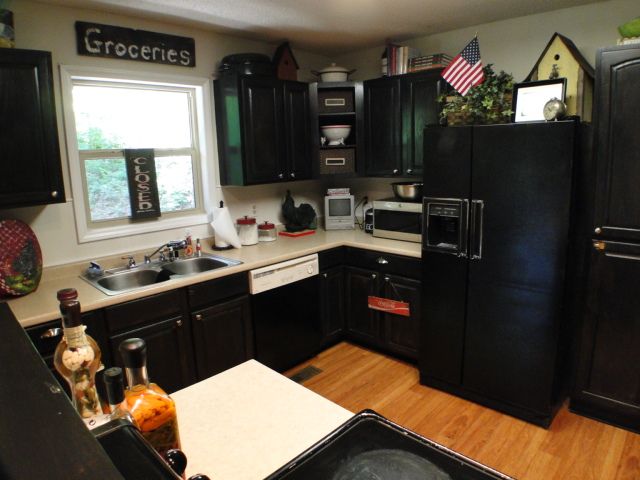 This home features a country kitchen with black cabinets, Bald Head Realty Franklin NC