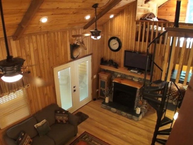 The living room of this cabin is warm and cozy with soaring vaulted ceiling, John Becker Bald Head Cullowhee NC