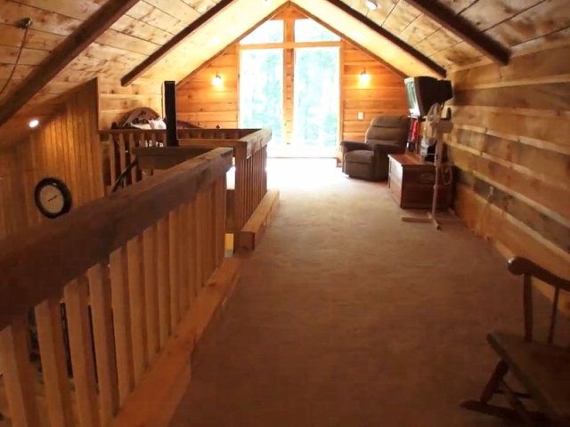 A spiral staircase leads to the bonus loft of this adorable log cabin near Lake Glenville NC