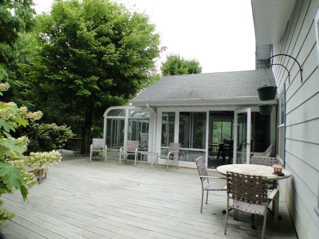 There is a gorgeous sunroom with lots of window leading to a composite deck, Cabins for Sale in Franklin NC
